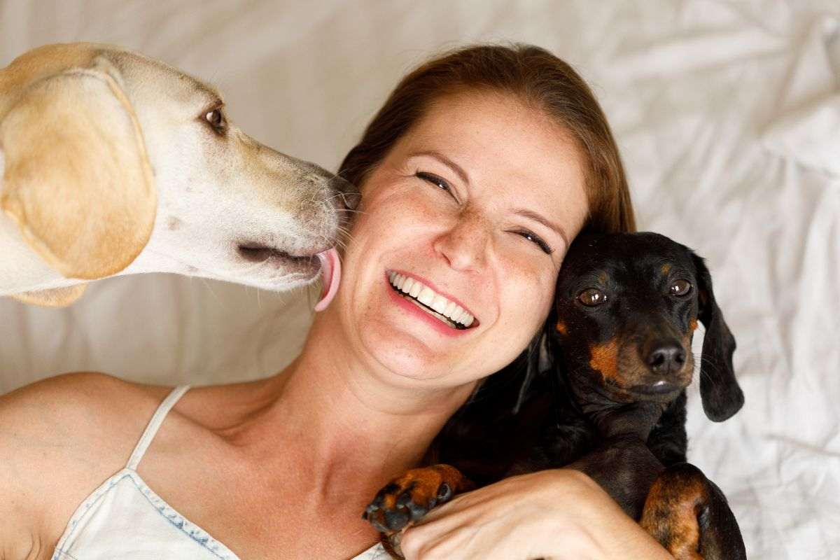 Ragazza gioca insieme ai suoi cani