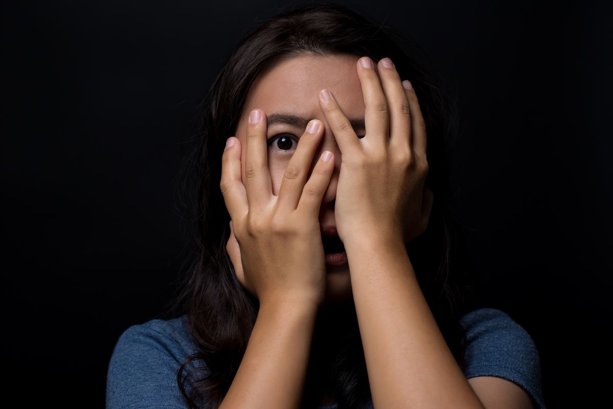 Una donna che si copre il volto dallo spavento